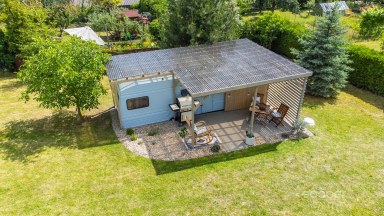 Příjemná venkovská zahrada s rekreačním karavanem a terasou.